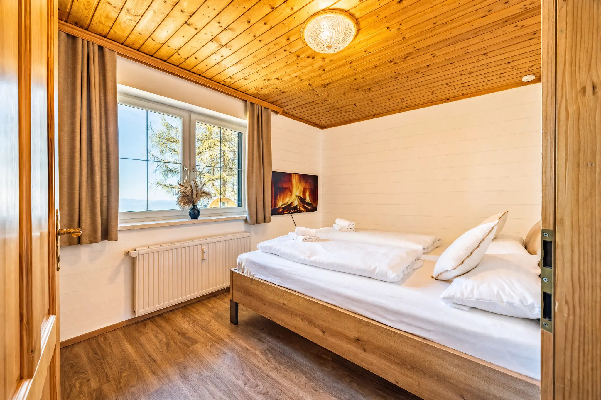 Schlafzimmer 2 Berglodge Hochrindl — Kingsize-Bett mit Bergblick und Smart TV