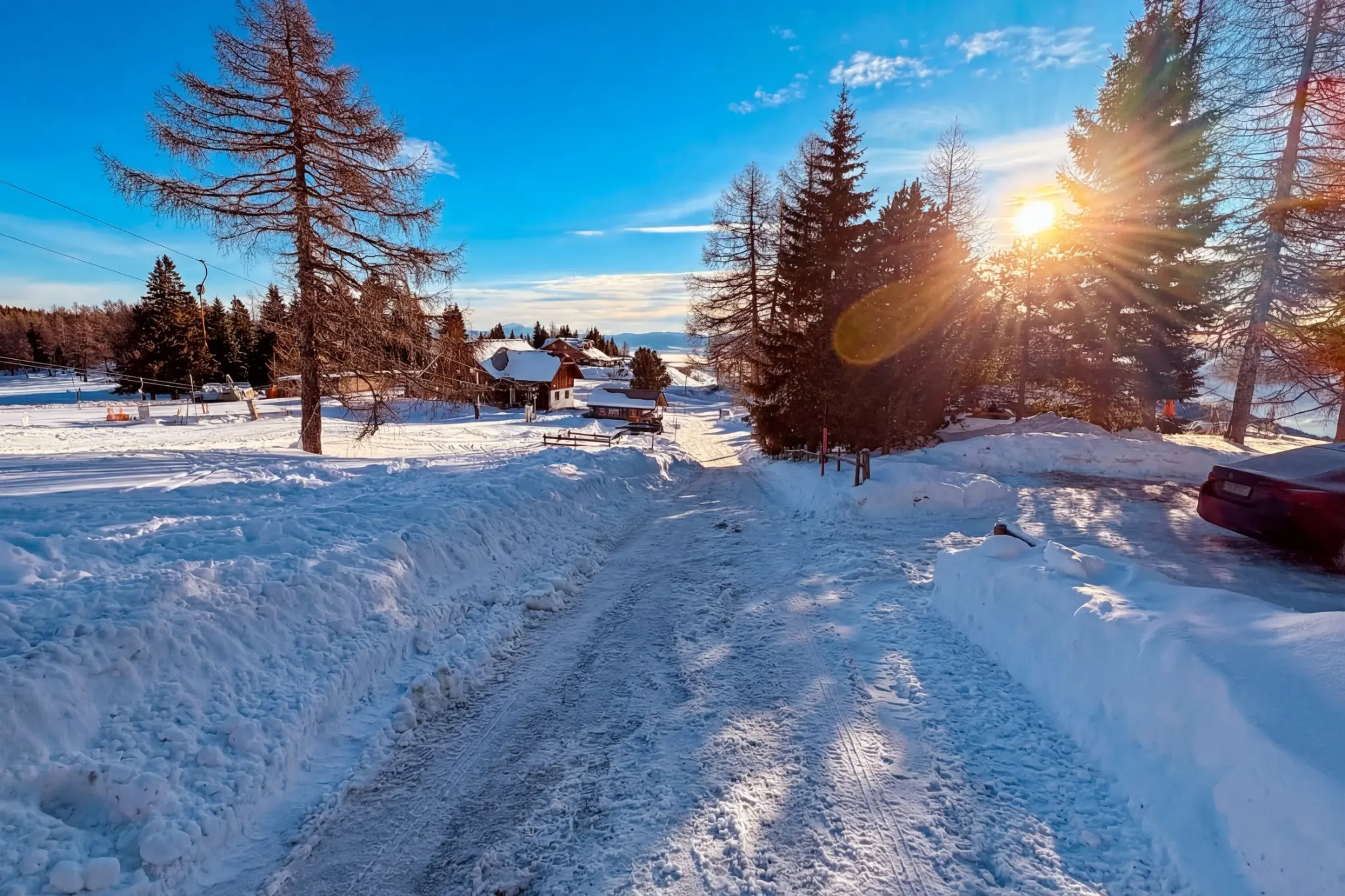 Winter arrival road at Hochrindl in sunshine and snow